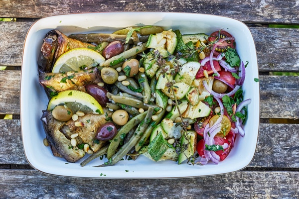 Gegrilltes H&auml;hnchen mit Gem&uuml;se und roten Zwiebeln auf wei&szlig;em Teller, Holztisch, Foto: Oliver Giel