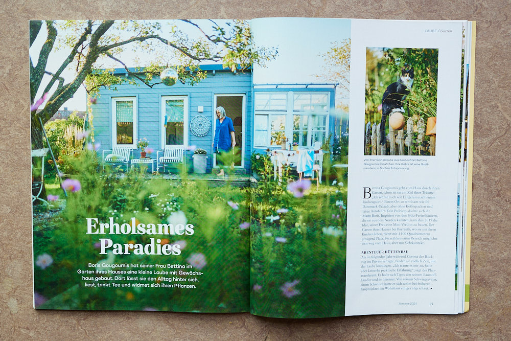 Eine aufgeschlagenes Magazin von LandlustZuhause mit einer Fotoreportage vom Fotografen Oliver Giel über eine hübsche Gartenlaube