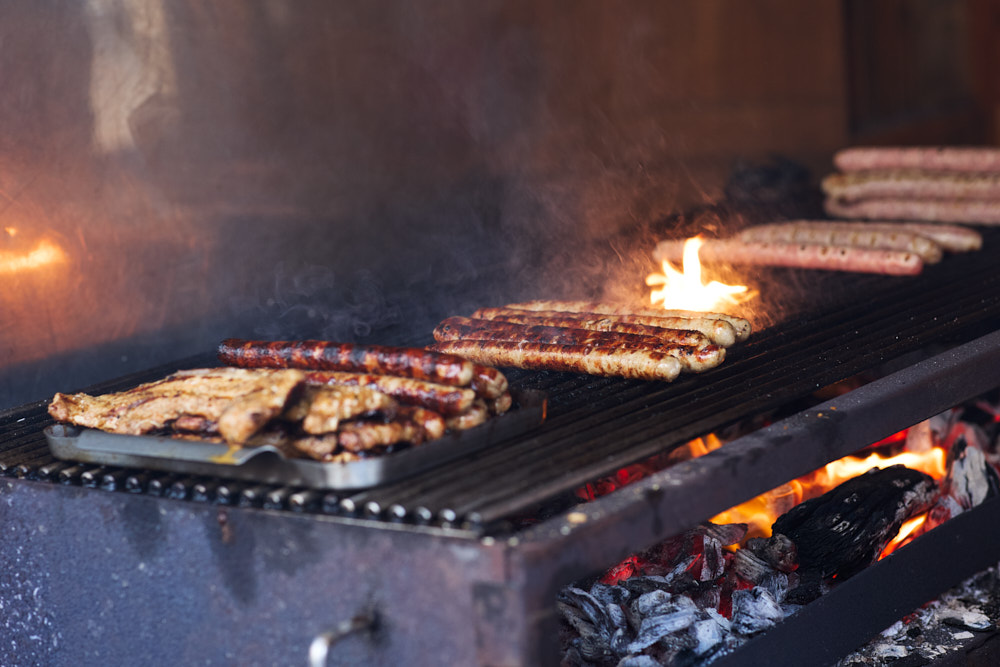 Bratw&uuml;rste und Fleisch auf Holzkohlegrill mit Flammen und Rauch, Ha&szlig;furter Stra&szlig;enfest, Oliver Giel