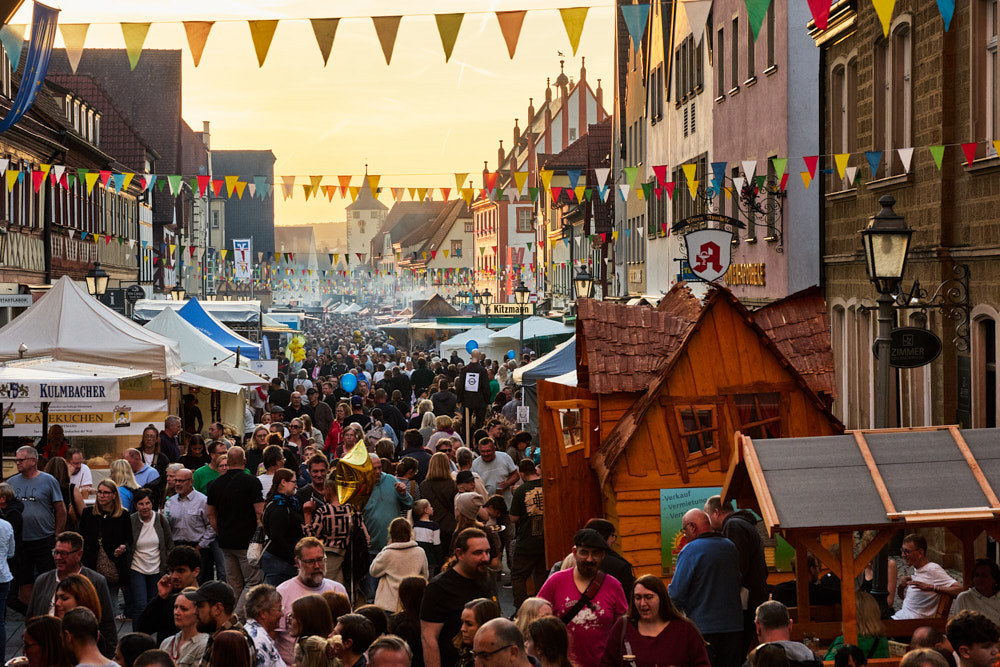 Menschenmenge auf Stra&szlig;enfest in Ha&szlig;furter Altstadt, bunte Wimpelketten, Marktst&auml;nde, Abendlicht, Oliver Giel