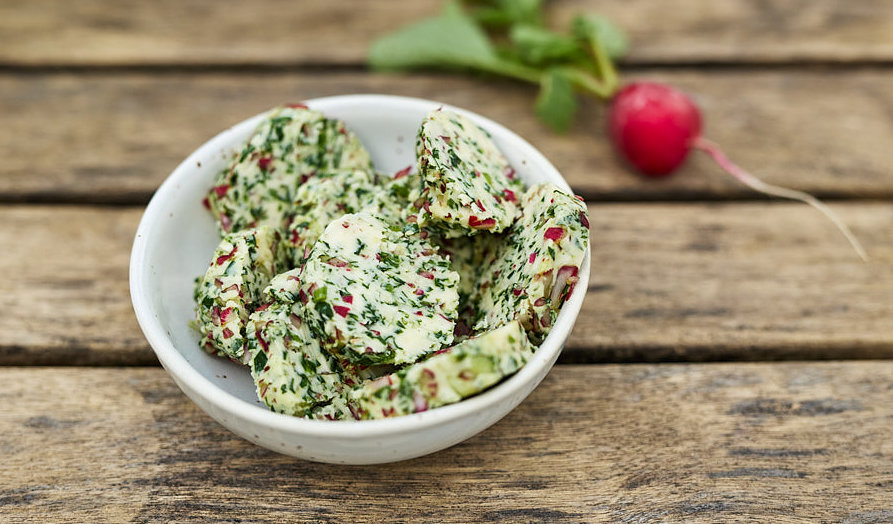Radieschenbutter mit Kr&auml;utern in wei&szlig;er Schale auf Holztisch, Foto: Oliver Giel