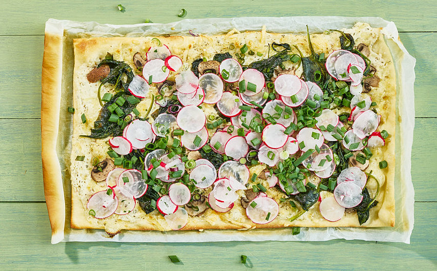 Flammkuchen mit Cr&egrave;me fraîche, Radieschen, Lauchzwiebeln und Kr&auml;utern auf Backpapier, Foto: Oliver Giel