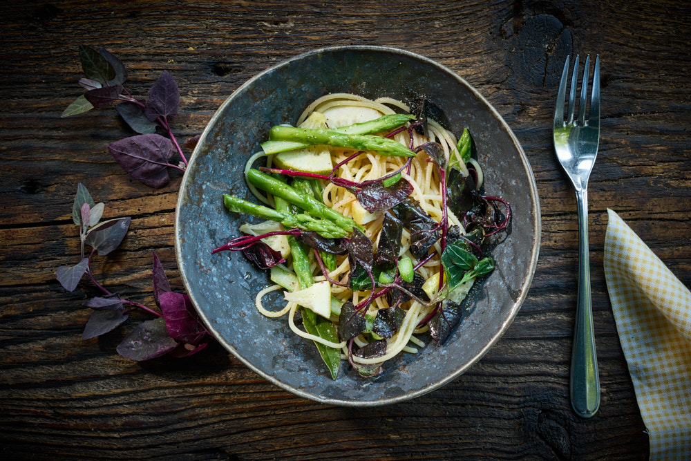 Spaghetti mit Gartenmelde, gr&uuml;ner Spargel in grauem Teller auf Holztisch, Overhead-Shot, Foto: Oliver Giel