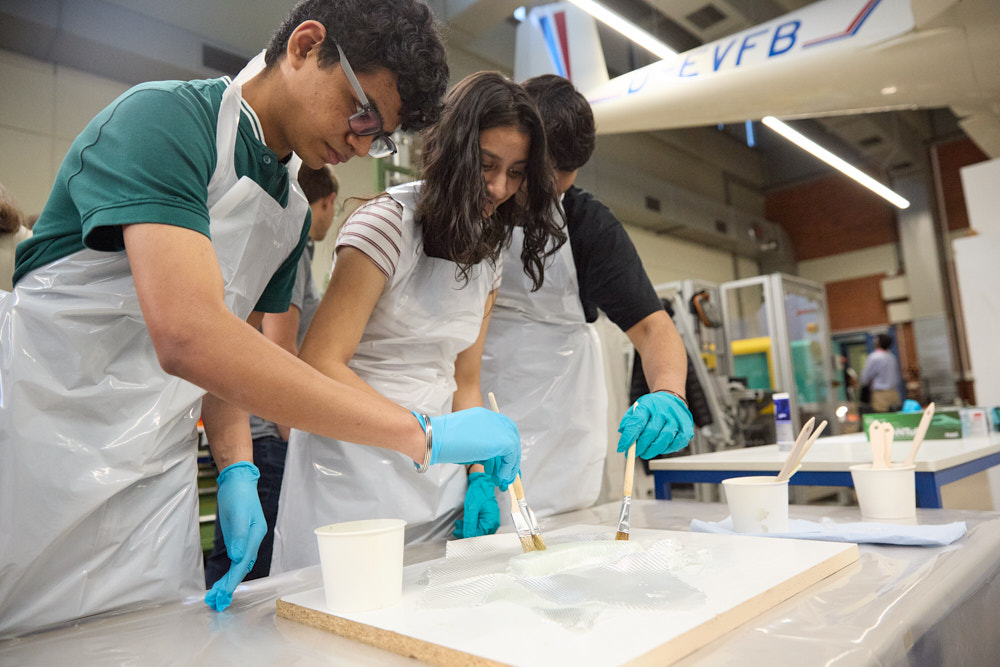 Jugendliche bei naturwissenschaftlichem Experiment mit Pinseln und Schutzhandschuhen im Klassenzimmer, Foto: Oliver Giel